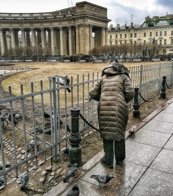 Rear view of man walking on cobblestone