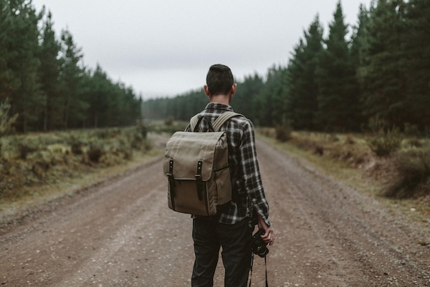 Photo rear view of a man walking on countryside landscape