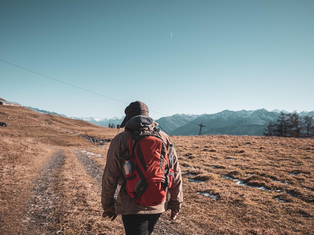 Photo rear view of man walking on field against clear sky