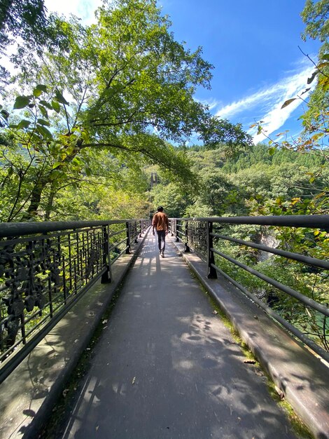 Photo rear view of man walking on footbridge