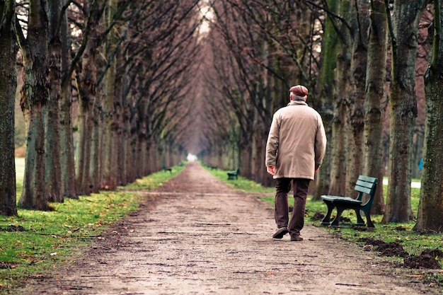 Photo rear view of man walking on footpath