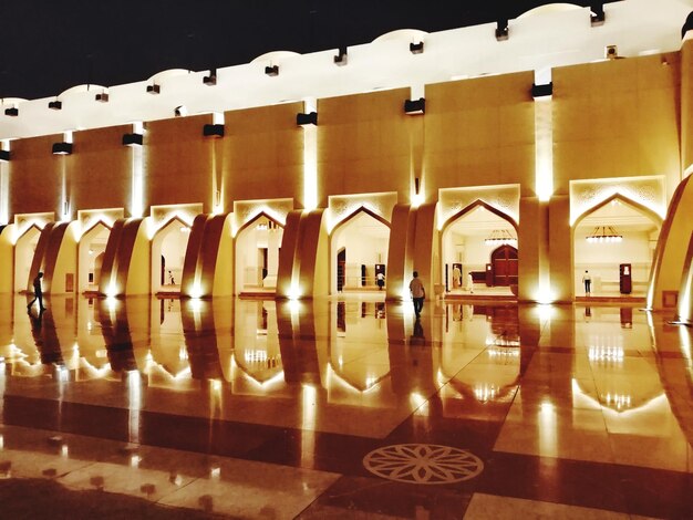 rear view of man walking in illuminated mosque