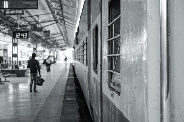 Foto vista posteriore di un uomo che cammina alla stazione ferroviaria