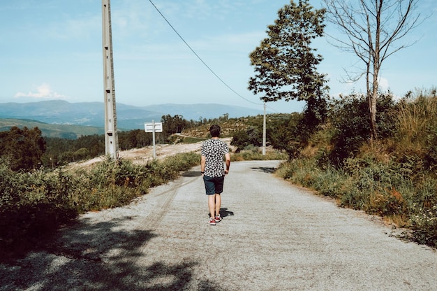 Photo rear view of man walking on road against sky