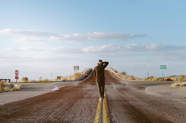 Photo rear view of man walking on road against sky