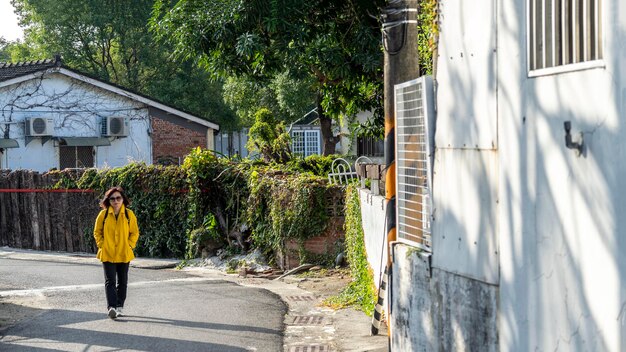 Photo rear view of man walking on road amidst buildings