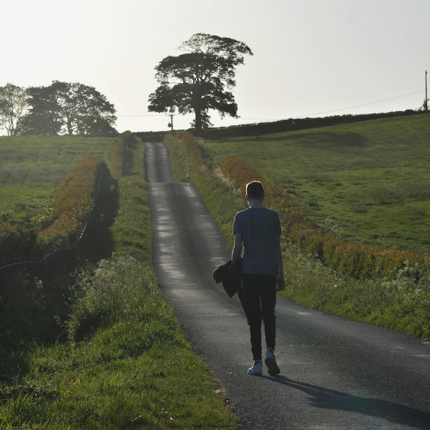 Photo rear view of man walking on road