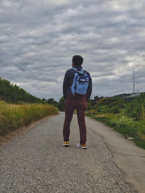 Rear view of man walking on road