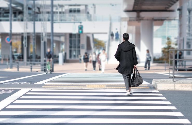 Photo 道路を歩いている男の後ろの景色