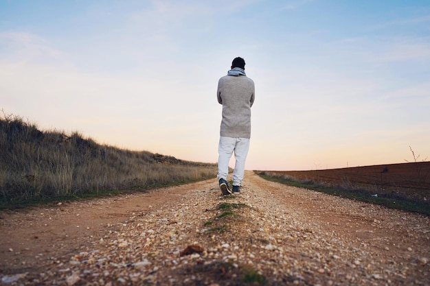 Rear view of man walking on road