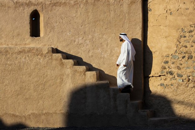 Photo rear view of man walking on staircase against building