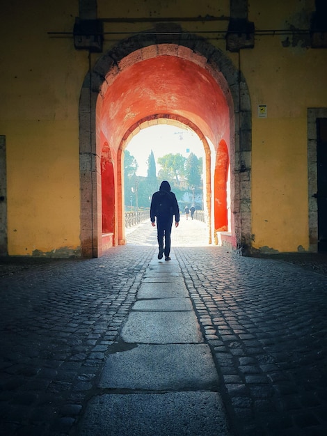 Photo rear view of man walking in tunnel