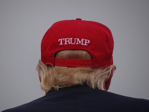 Photo rear view of man wearing cap with text against gray background