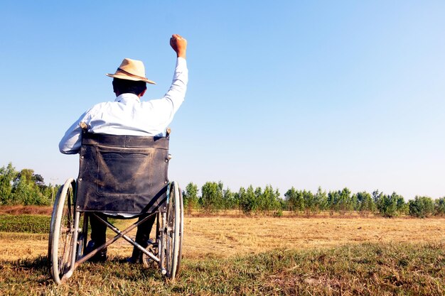 Rear view of man wearing hat on field against sky