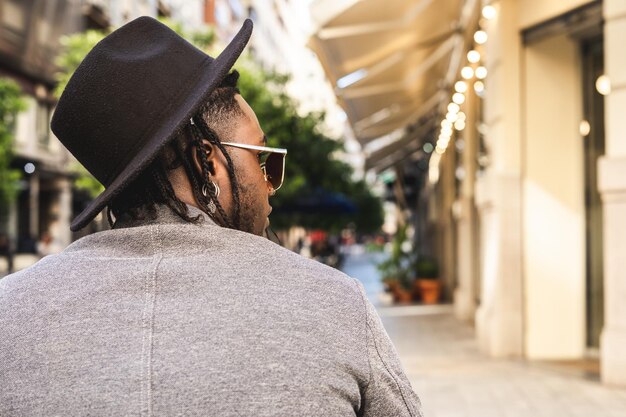 Foto vista posteriore di un uomo che indossa un cappello seduto in città