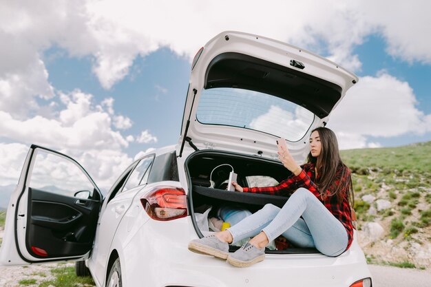 車に座っている男性が暖かい服を着ている後ろの景色