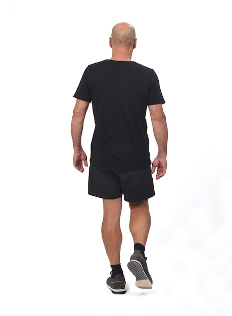 Rear view of a man wearing with sportswear t-shirt and shorts walking on white ,