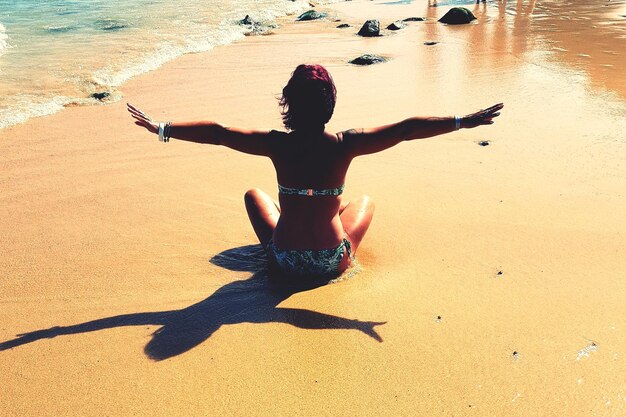 Rear view of man with arms raised on beach