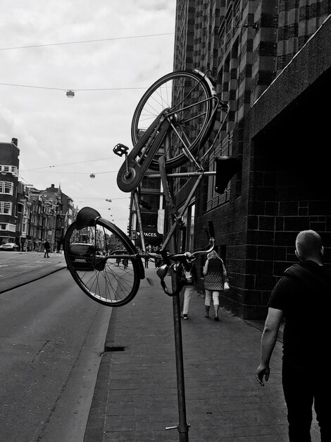 Photo rear view of man with bicycle standing in city