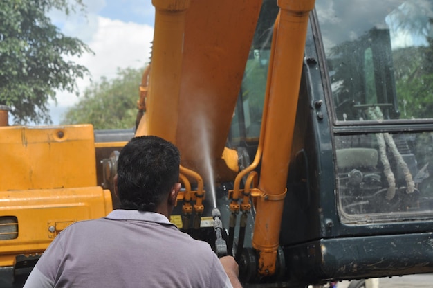 Photo rear view of man working at cleaning excavator construction site