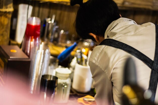 Photo rear view of man working on glass at restaurant