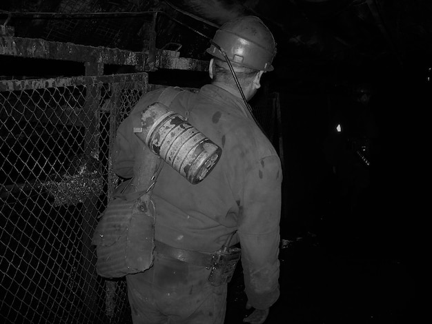 Rear view of man working in mine