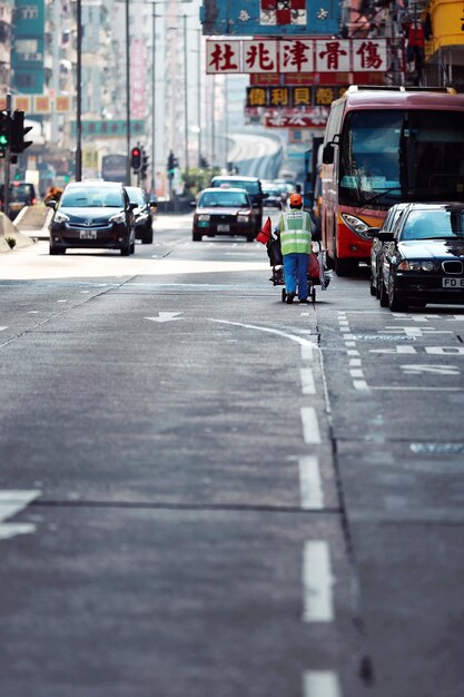 Foto vista posteriore di un operaio manuale sulla strada in città