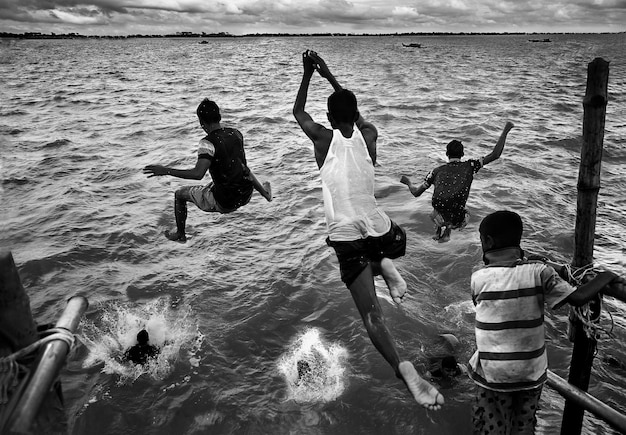 Rear view of men jumping into sea