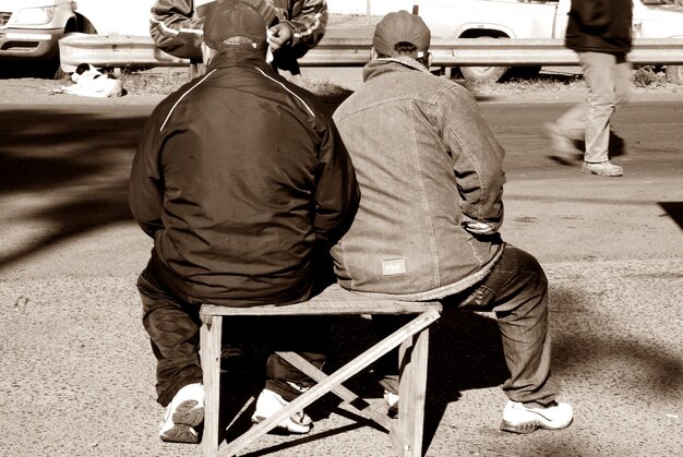 Photo rear view of men sitting outdoors