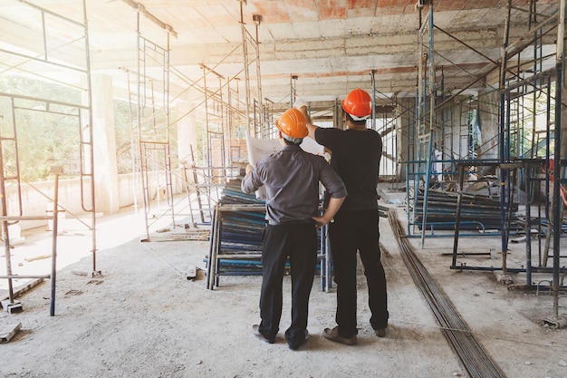 Photo rear view of men standing at construction site