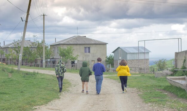 Photo rear view of men walking on field against sky