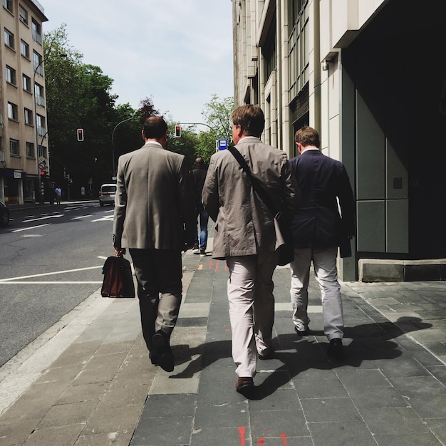 rear view men walking in street