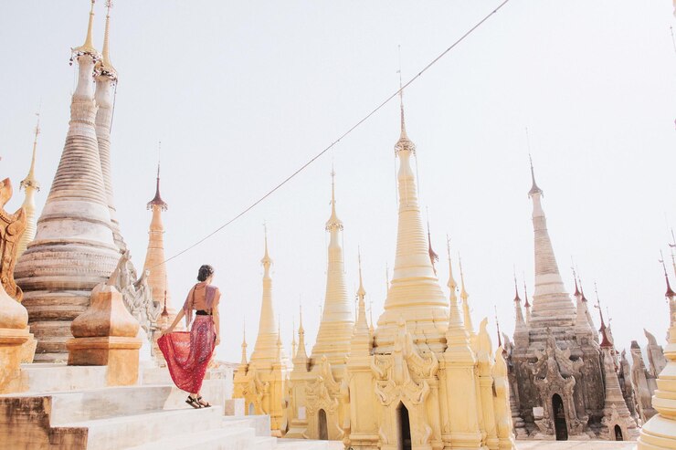 Photo 明るい空の前で寺院に立っている中年女性の後ろの景色