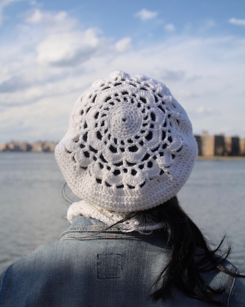 Rear view of mid adult woman wearing knit hat by sea