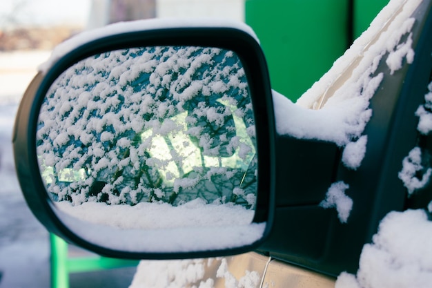 Rear view mirror of a car covered in snow