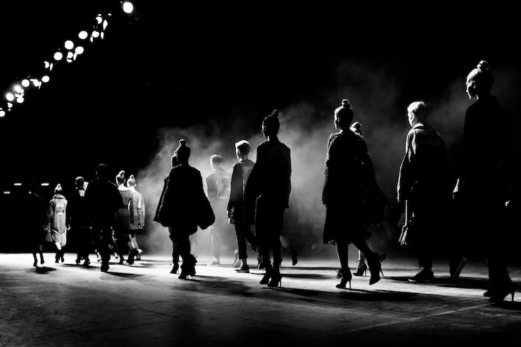 Photo rear view of models in row during fashion show