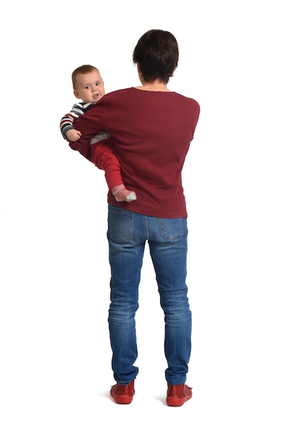 Rear view of a mother carrying her baby on white background