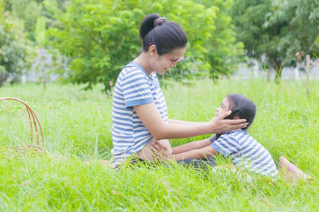 Rear view of mother and daughter on grass