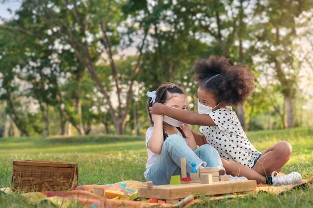 Rear view of mother and daughter sitting on grass