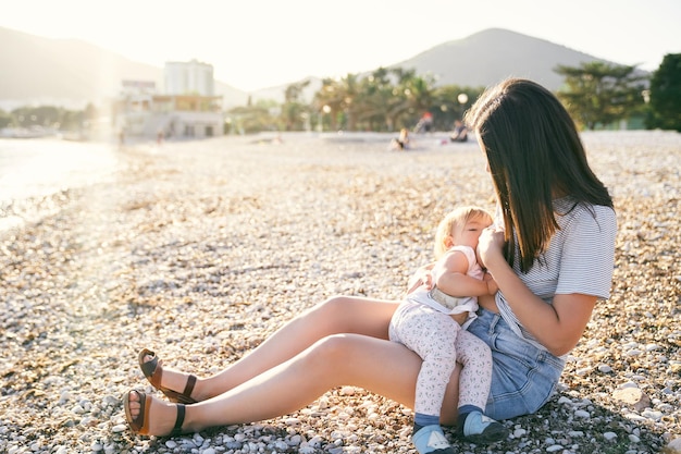 Photo rear view of mother and daughter sitting outdoors