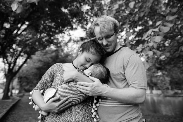 Photo rear view of mother holding baby girl outdoors