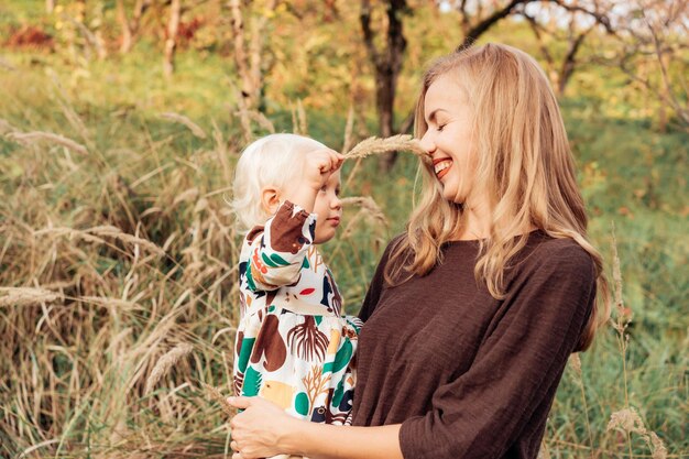 Photo rear view of mother holding daughter outdoors