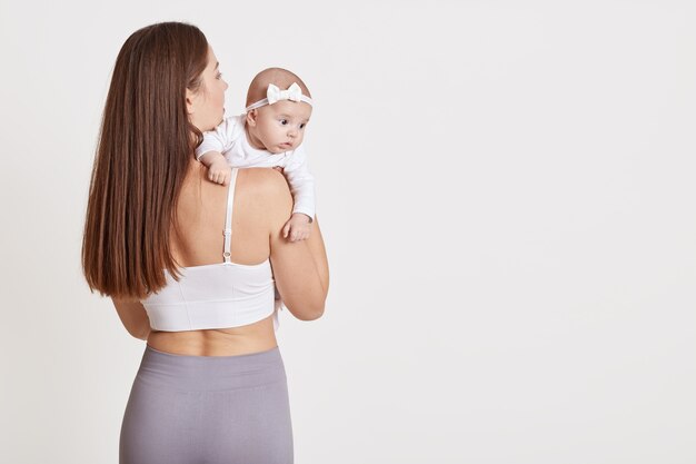 Rear view of mother and newborn standing together