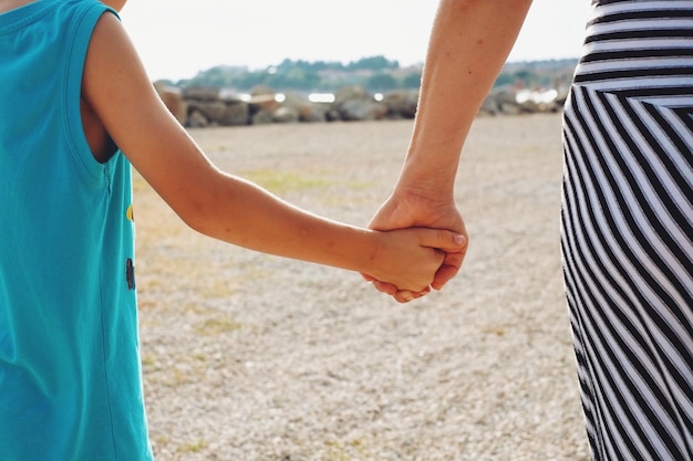 Vista posteriore di madre e figlio che si tengono per mano