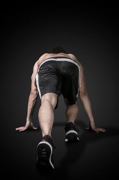 Rear view of a muscled man ready to run