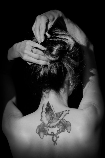 Photo rear view of naked woman with tattoo