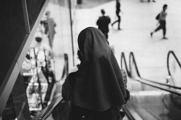 Сзади монахиня на эскалаторе