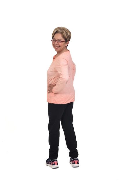 Photo rear view o f a full portrait of senior woman with sportswear looking at camera on white background