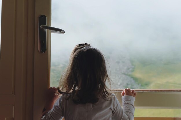 写真 窓から見る女の子の後ろの景色