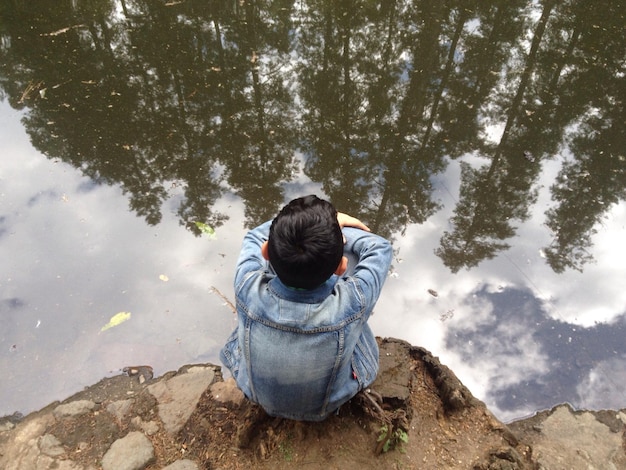 写真 湖岸でうなずいている男の子の後ろの景色